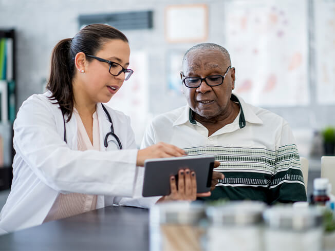 Female physician showing information on a table to a male patient