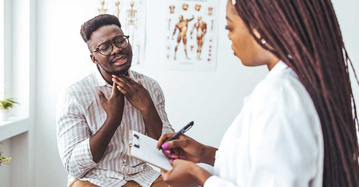 Man with eyes closed touching painful throat