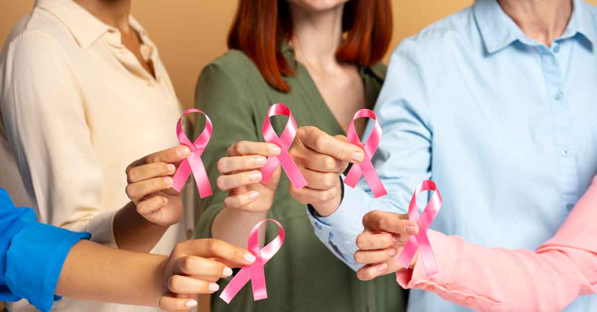 Group of people holding pink breast cancer awareness ribbons