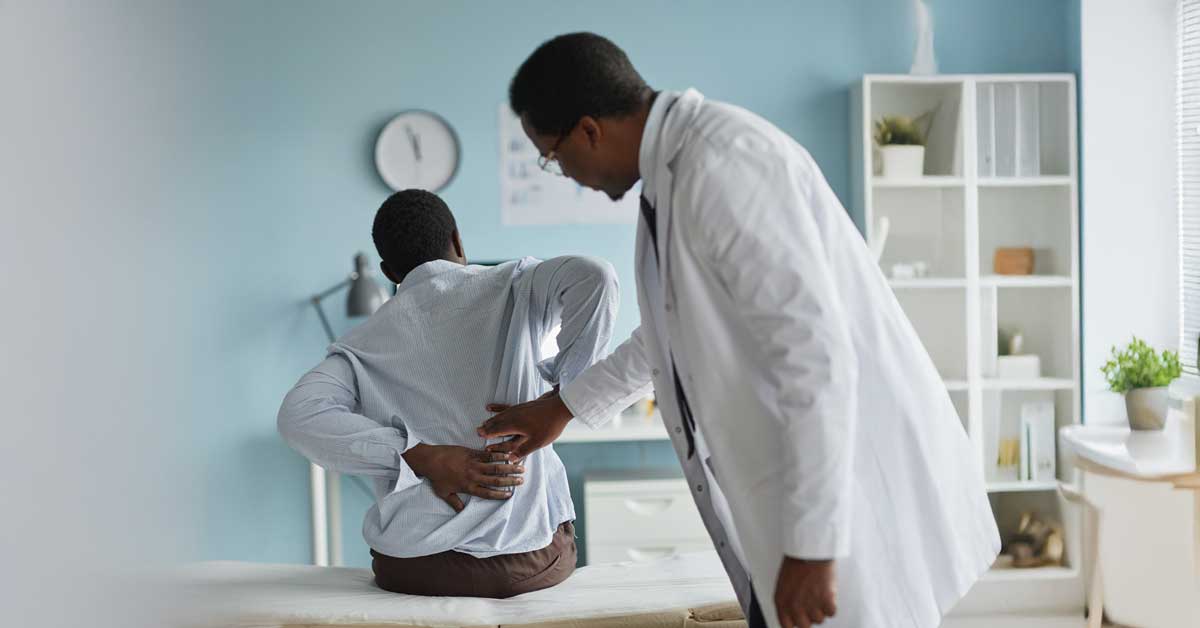 Man with back pain being examined by doctor
