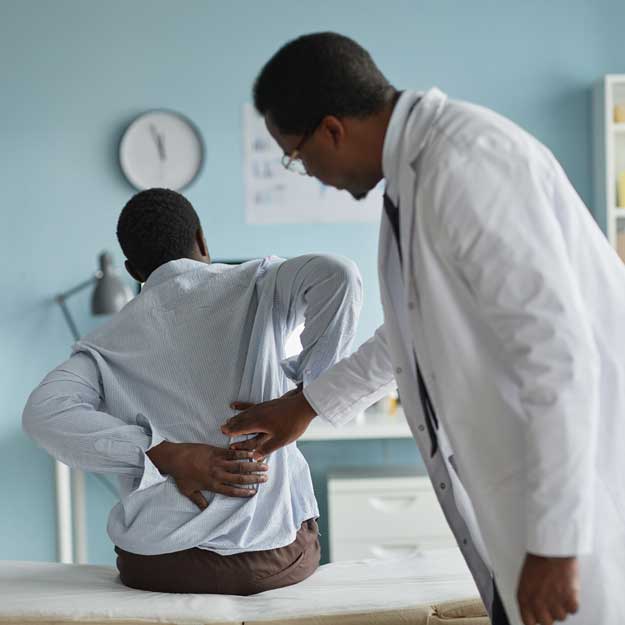 Man with back pain being examined by doctor