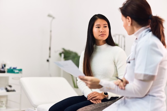 Woman discussing cancer screening results with her doctor in a modern clinic, illustrating 2026 cancer trends, survival rates, and treatment options.