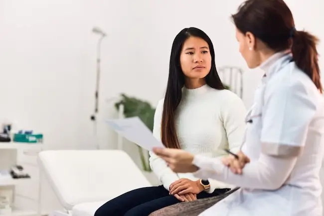 Woman discussing cancer screening results with her doctor in a modern clinic, illustrating 2026 cancer trends, survival rates, and treatment options.