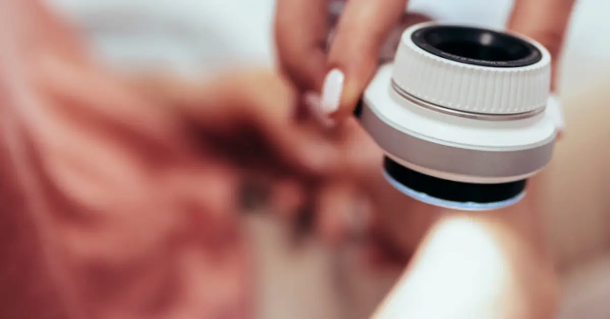 Clinician using a dermatoscope to examine a patient's arm during a skin cancer screening