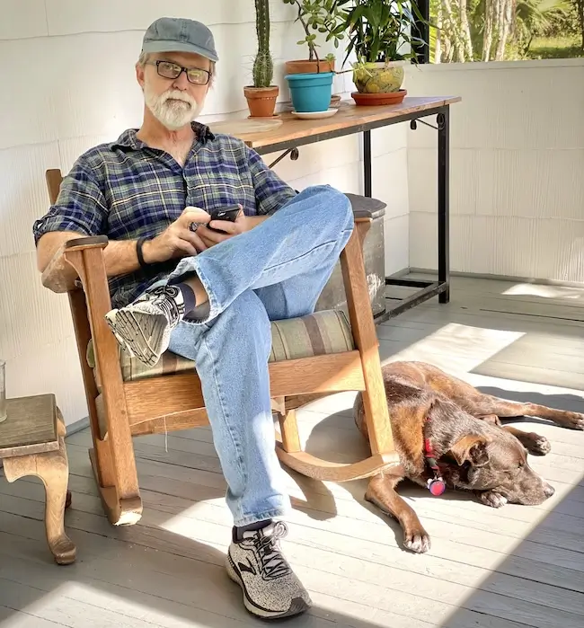 Dan Swanson, multiple myeloma survivor, relaxing on his porch with his dog