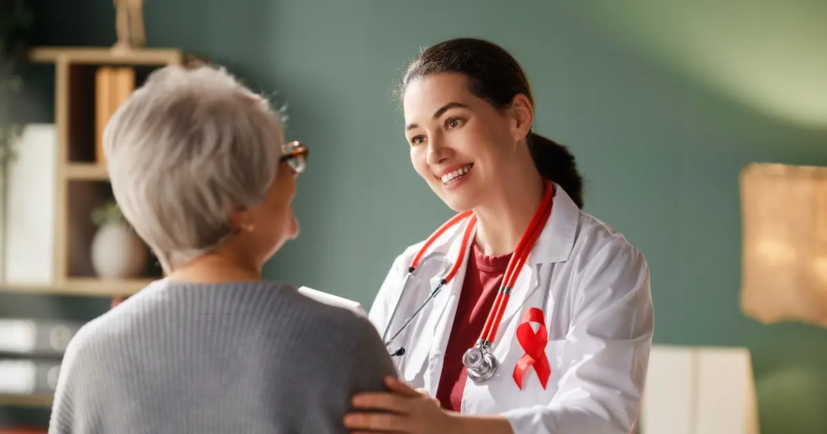 Female oncologist smiling and reassuring senior patient during a cancer care appointment