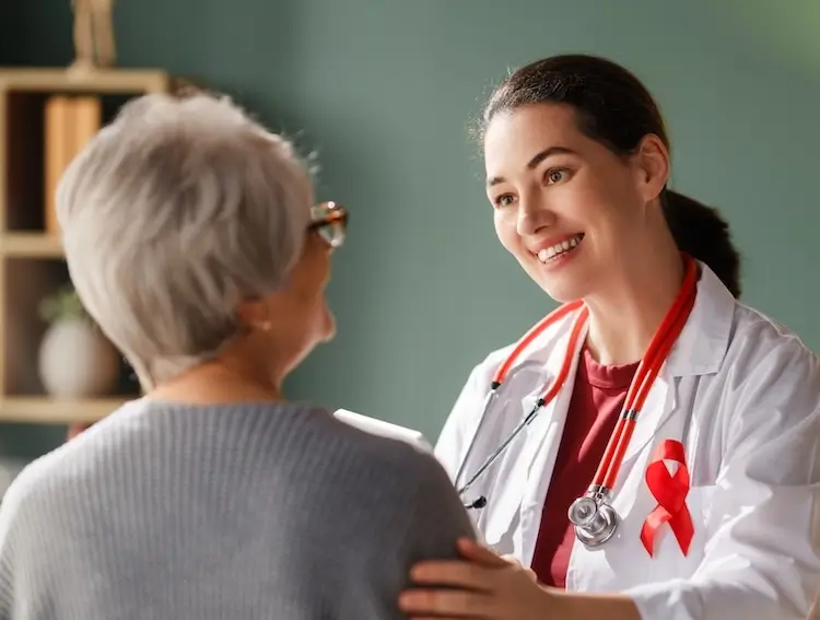 Compassionate Care in Community Oncology Female oncologist smiling and reassuring senior patient during a cancer care appointment - Florida Cancer Specialists & Research Institute.